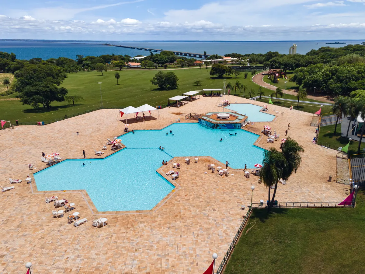 Piscina em forma de estrela com espreguiçadeiras, hidromassagem e rio Paraná ao fundo