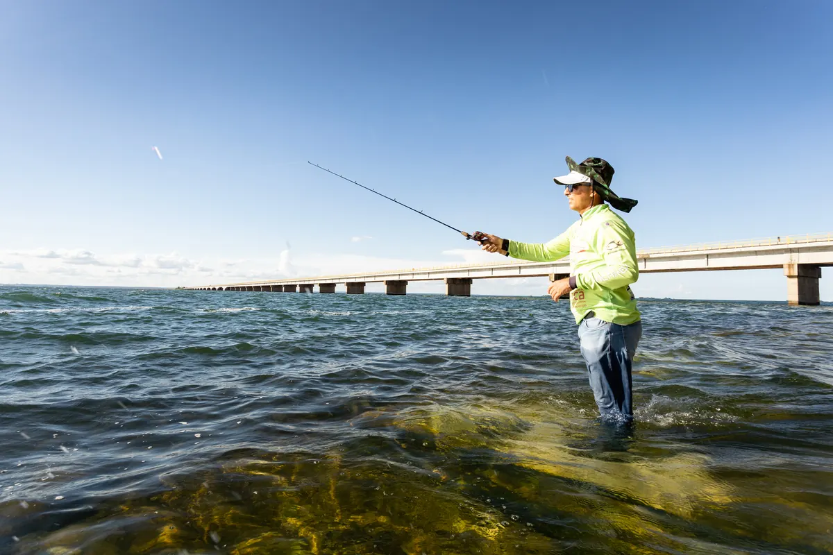 Pescador no rio Paraná com a ponte rodoferroviária ao fundo