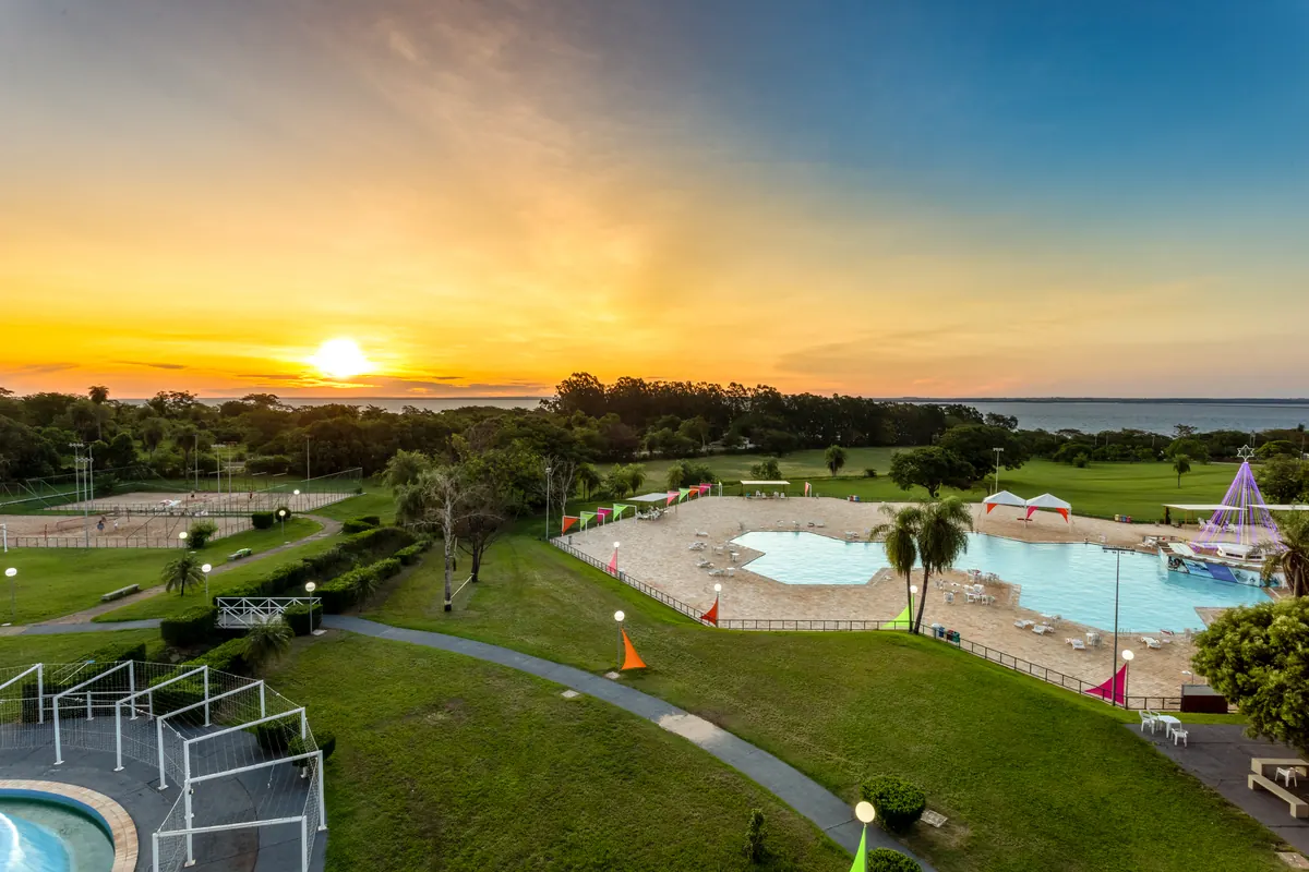 Sol se pondo sobre o rio Paraná visto do alto do jardim e da piscina do hotel