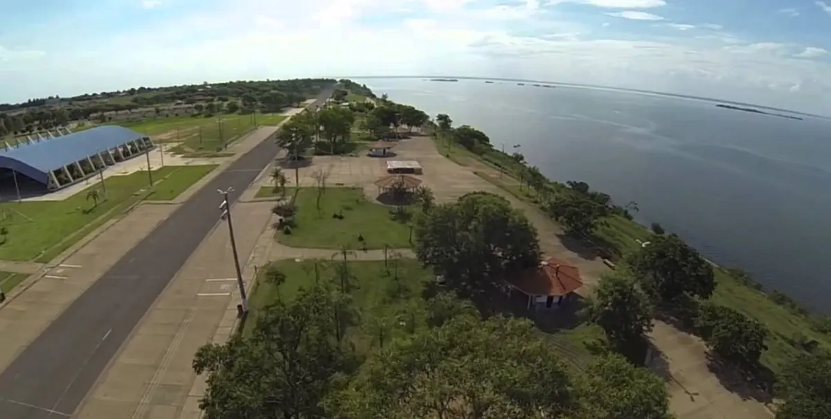 Vista aérea da orla fluvial de Presidente Epitácio, com avenida, gramados, árvores e o rio Paraná